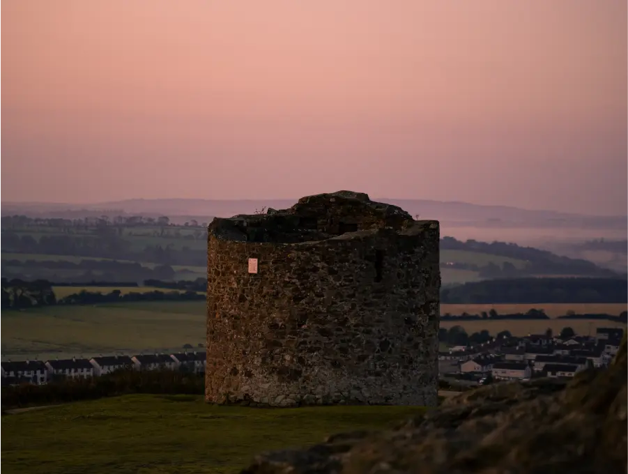 Ruin of stone watchtower on Vinegar Hill overlooking the surrounding Wexford countryside, at sunset.