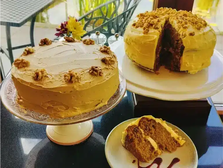 Two homemade iced cakes on display, including a walnut-topped cake and a sliced piece served on a plate in Café 98 in the National 1798 Rebellion Centre, Enniscorthy.