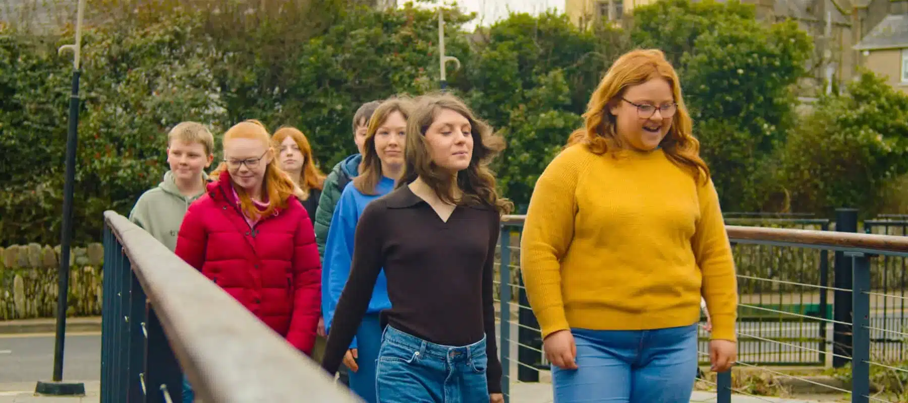 Group of young people walking together across a footbridge during a visit to Enniscorthy.